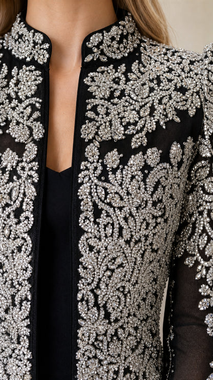 Close-up detail of silver beading and embroidery on black cropped jacket