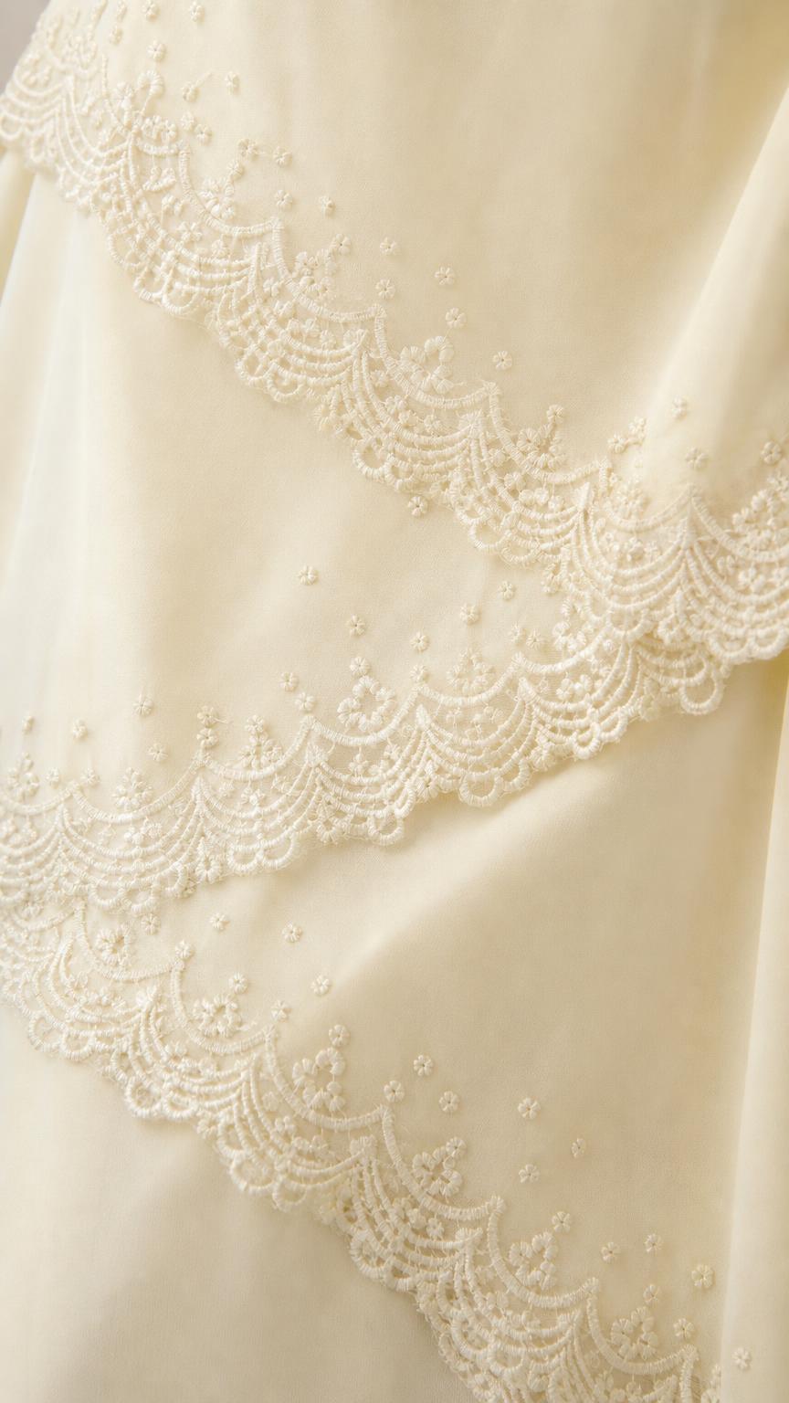 Close-up detail of lace trim on the tiered dress