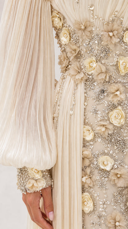 Close-up detail of champagne 3D floral appliqués, beadwork, and pleated sleeve cuff
