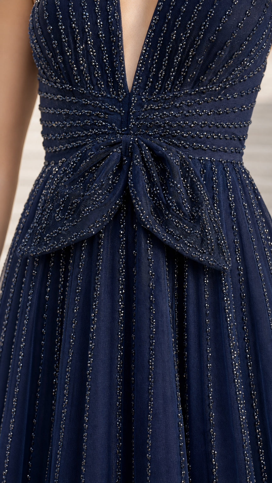 Close-up detail of beaded bodice and waist bow on navy gown