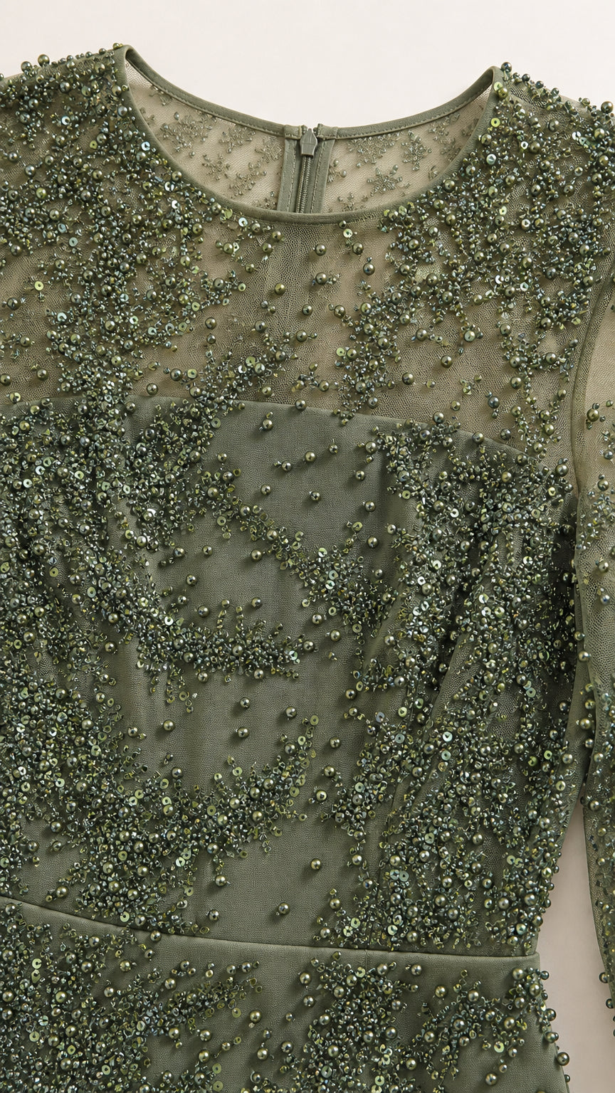 Close-up detail of green illusion mesh fabric with intricate bead and sequin embellishments