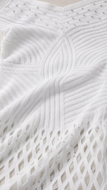 Close-up of white knit fabric texture and embellished bodice details