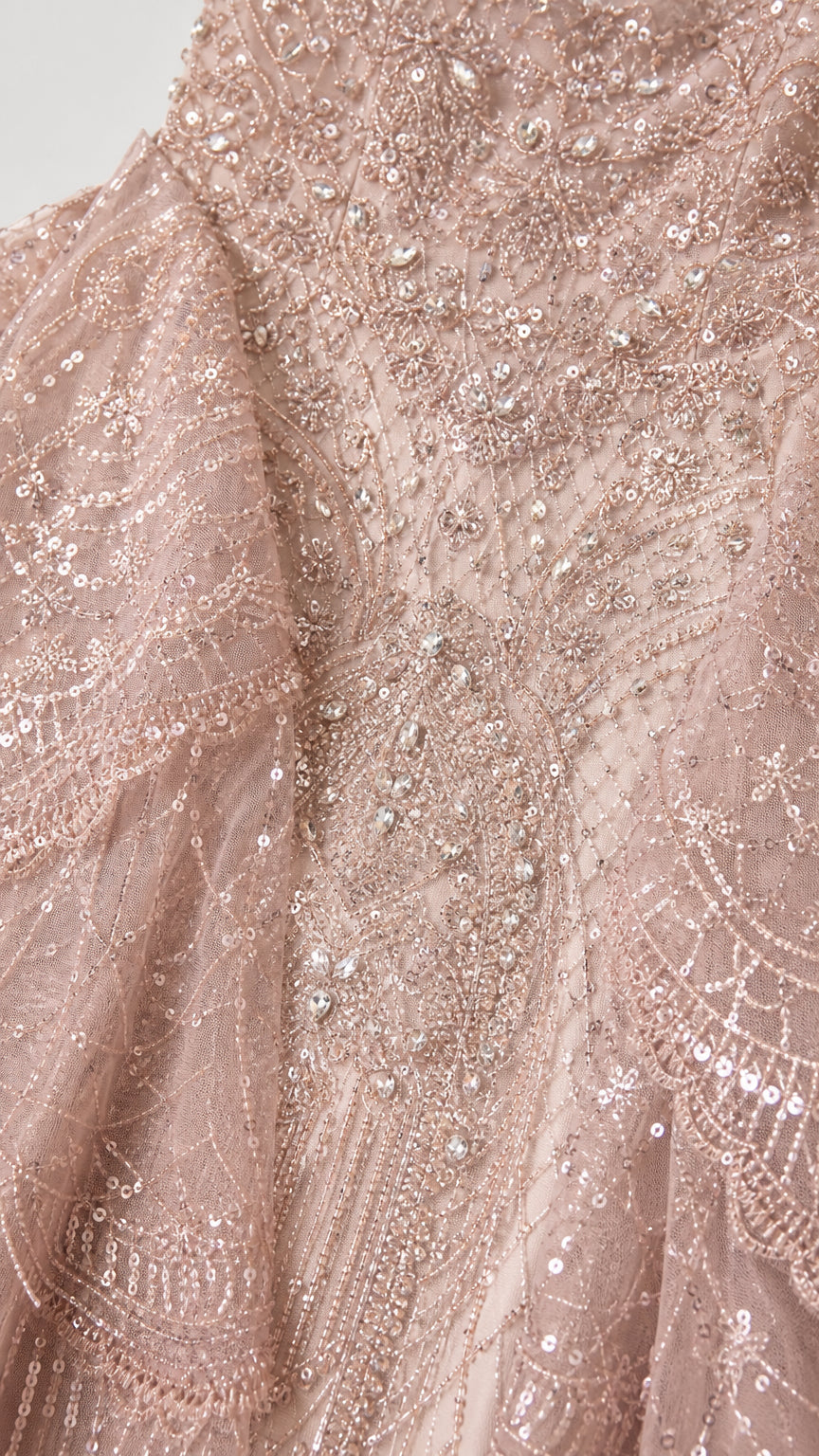 Close-up detail of dusty rose intricate beadwork, sequins, and lace embroidery