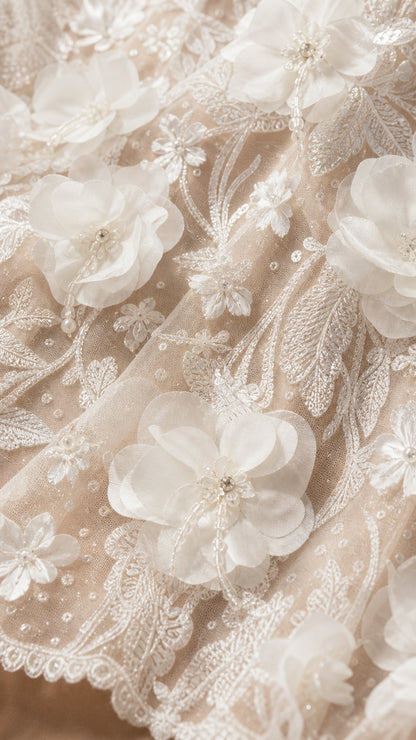 Close-up detail of 3D floral appliques and beadwork on dress