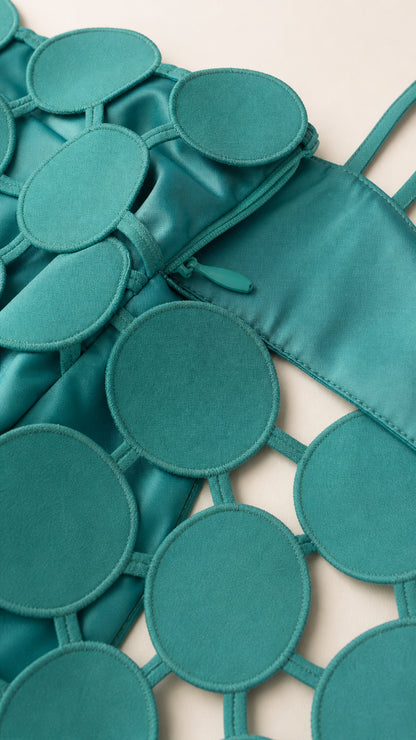 Close-up detail of teal cutout circle fabric and zipper