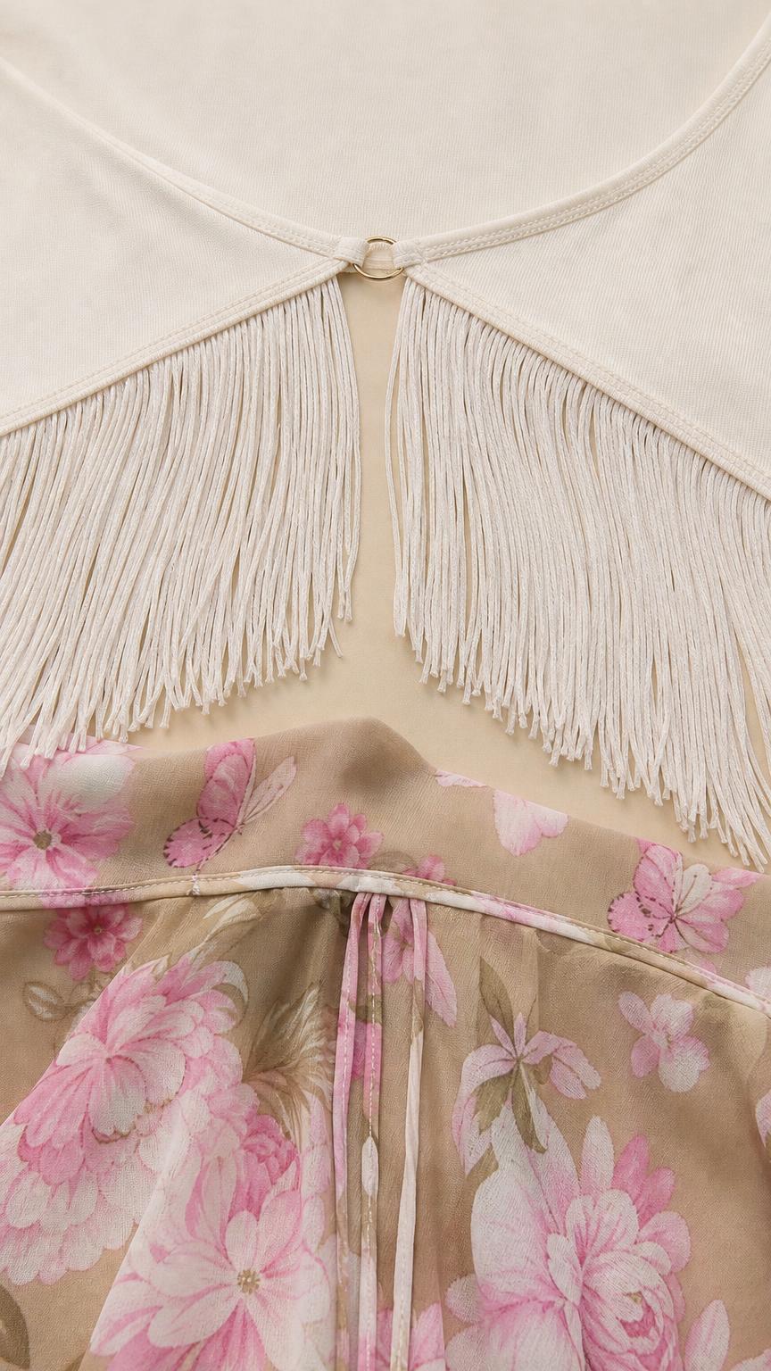 Close-up detail of front clasp and fringe on white top paired with floral skirt