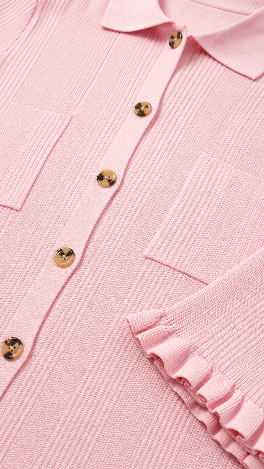 Close-up of polo collar, buttons, and ruffle sleeve detail