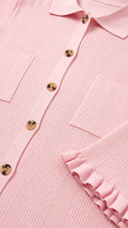 Close-up of polo collar, buttons, and ruffle sleeve detail