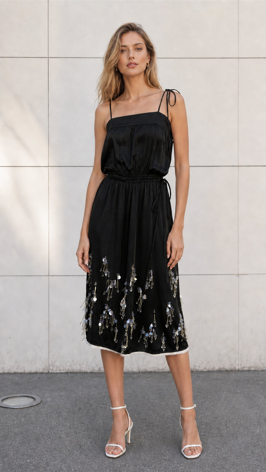 Front view of model wearing black satin embellished midi slip dress
