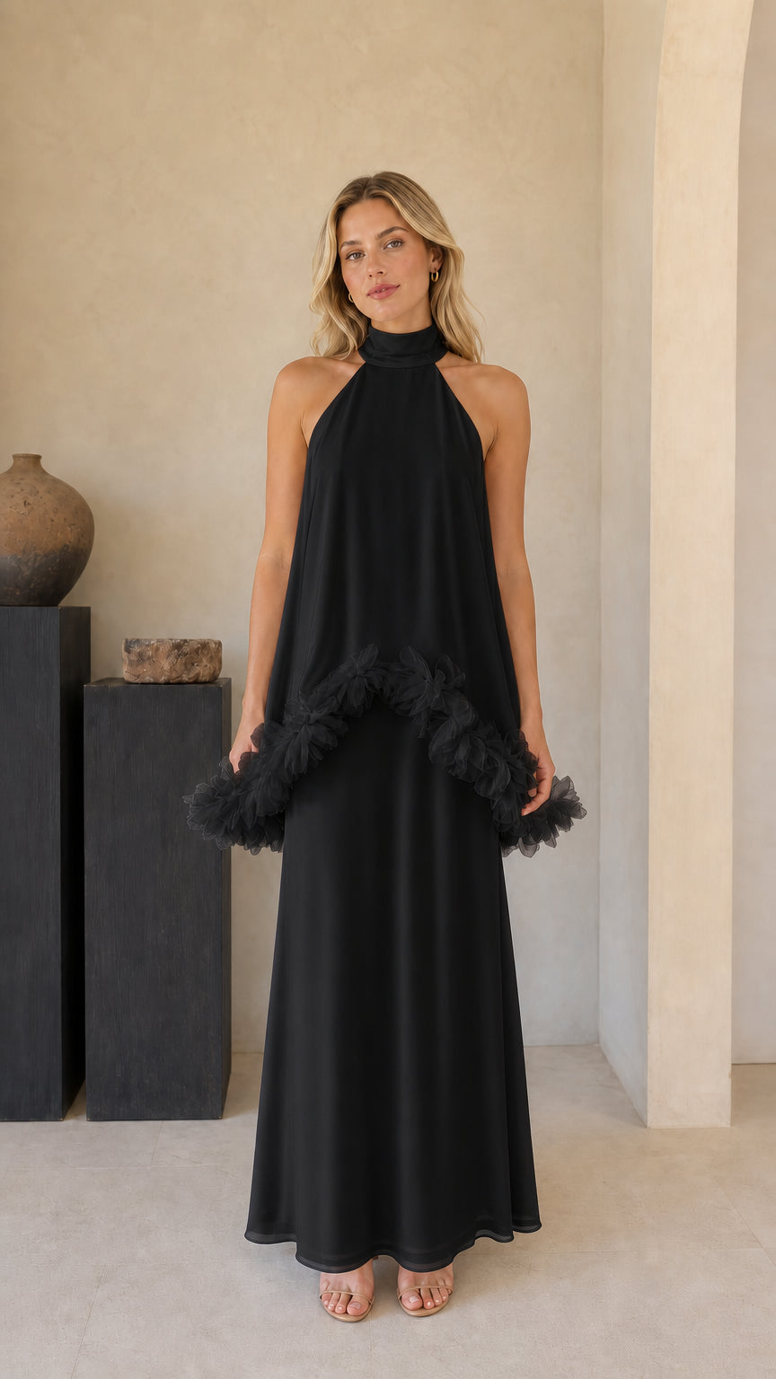 Model wearing black high-neck sleeveless tiered maxi dress