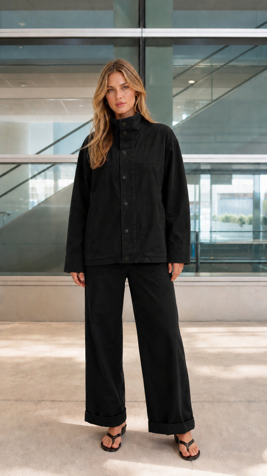 Woman wearing black two-piece stand-collar jacket and wide-leg pants set