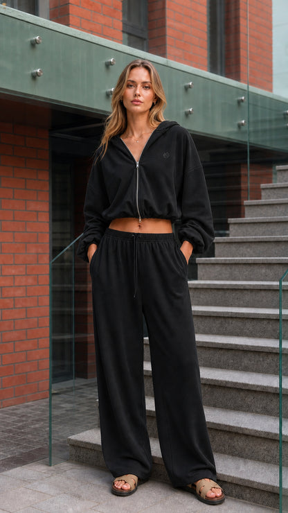 Woman wearing a black cropped zip hoodie and wide-leg pants set