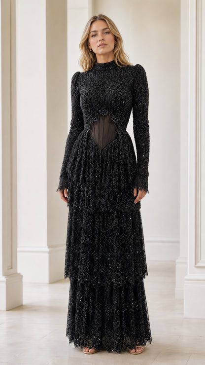 Model wearing black high neck beaded long sleeve tiered evening gown