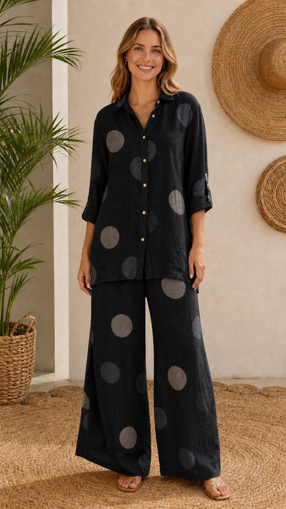 Front view of model wearing black polka dot shirt and wide-leg pants set