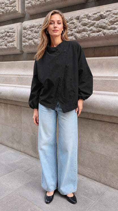 Model wearing the black asymmetrical button lantern sleeve blouse with wide-leg denim