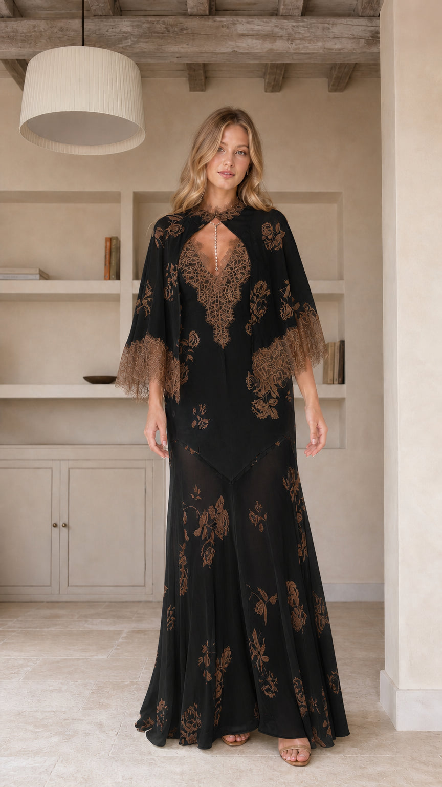 Model wearing black floral maxi dress with cape sleeves
