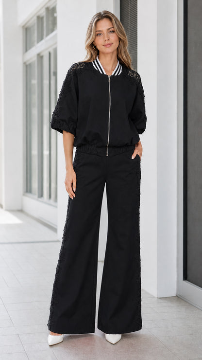 Front view of women's black lace appliqué zip jacket and wide-leg pant set