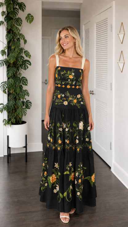 Front view of model wearing black floral embroidered tiered maxi dress