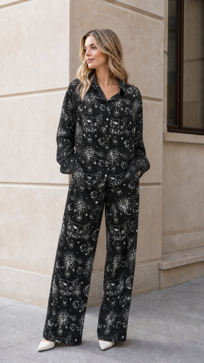 Woman wearing black celestial sun and moon graphic pajama set