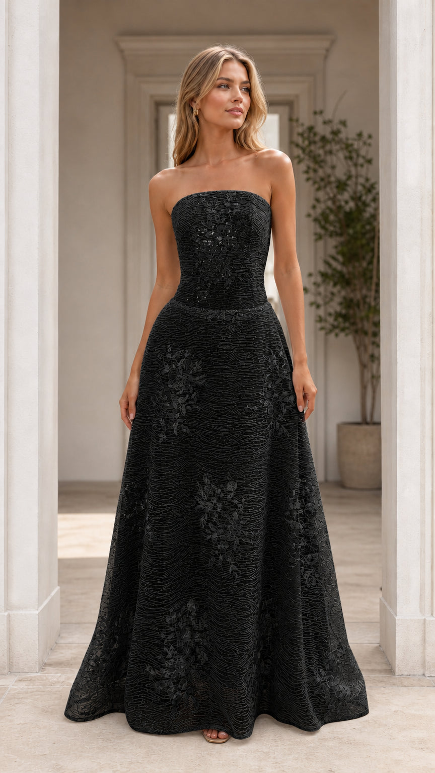Front view of model wearing black strapless formal evening dress