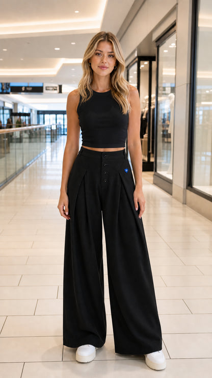 Front full-length view of model wearing black high-waisted wide-leg trousers with black crop top