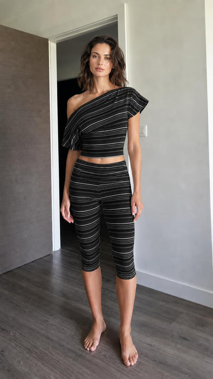 Woman wearing black striped one-shoulder crop top and capri leggings set