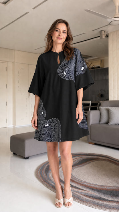 Model wearing black shift dress with contrast panels