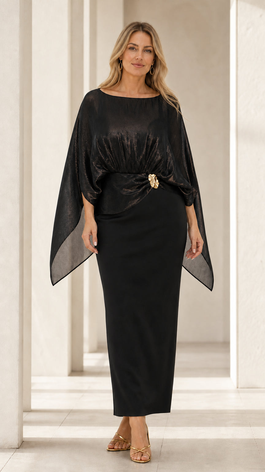 Front view of woman wearing black metallic capelet overlay maxi evening dress
