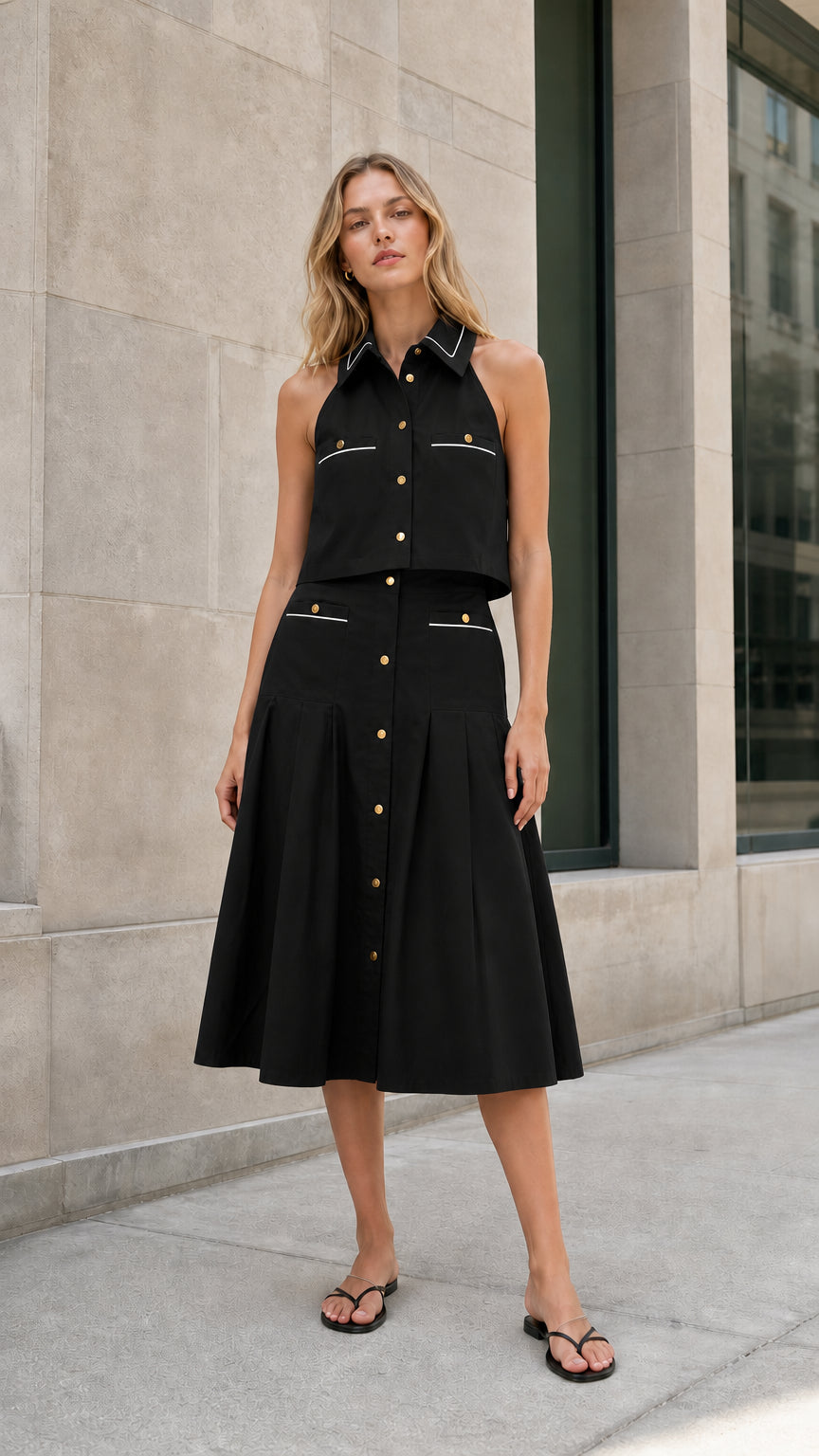Black sleeveless collared top and pleated midi skirt set shown from the front