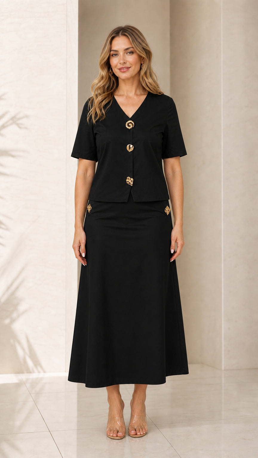 Front view of model wearing black two-piece V-neck top and maxi skirt set