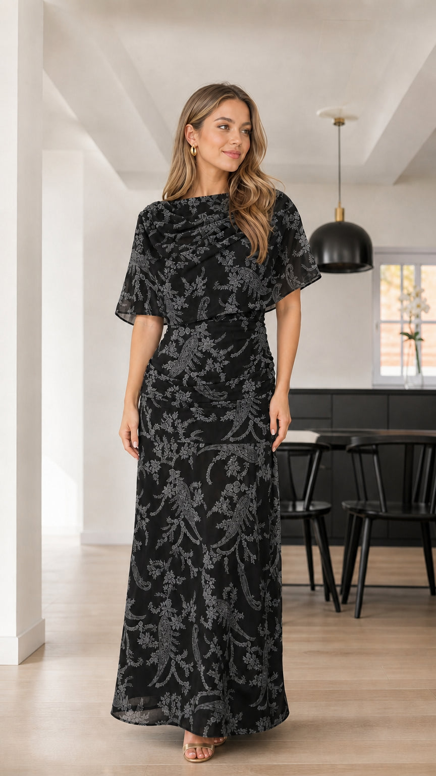 Front view of woman wearing Classic Black floral textured capelet maxi dress