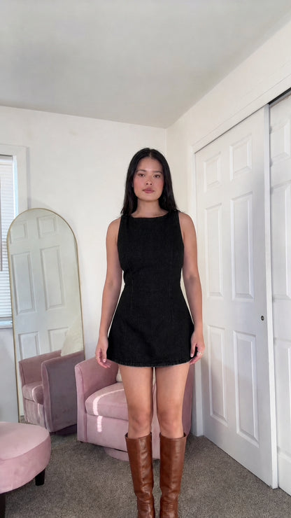 Front view of woman wearing black denim mini dress
