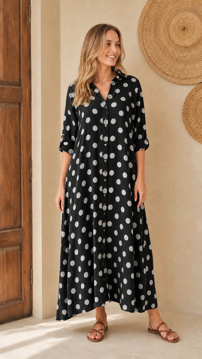 Front view of woman wearing black polka dot maxi shirt dress