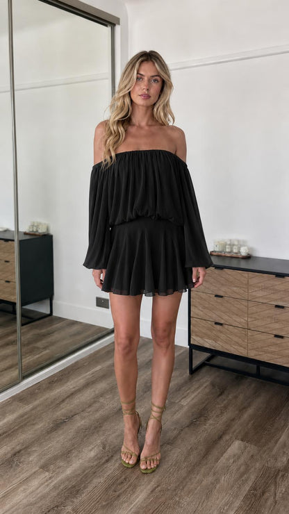Front view of model wearing black off-the-shoulder mini dress