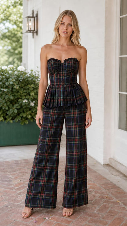 Model wearing black multi plaid strapless corset peplum top and wide leg pants set
