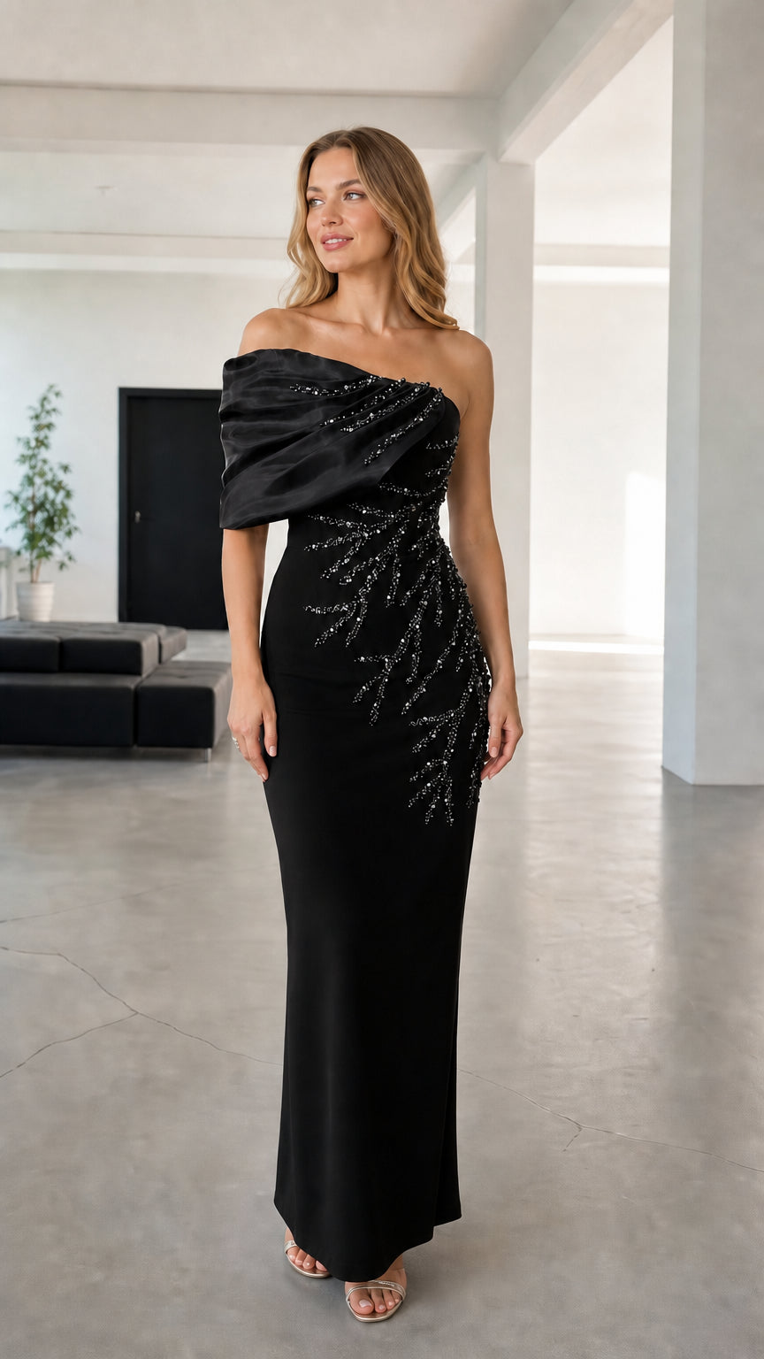 Full-length view of black asymmetric draped beaded evening maxi gown