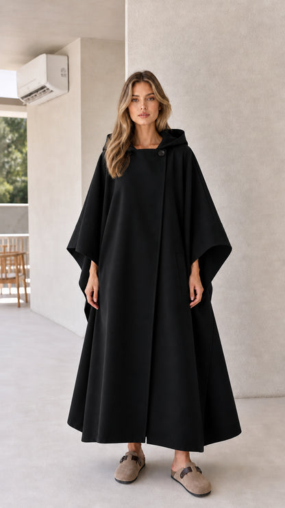 Model wearing black hooded maxi cape outerwear