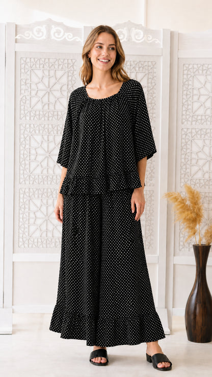 Front view of woman wearing black polka dot two-piece matching set