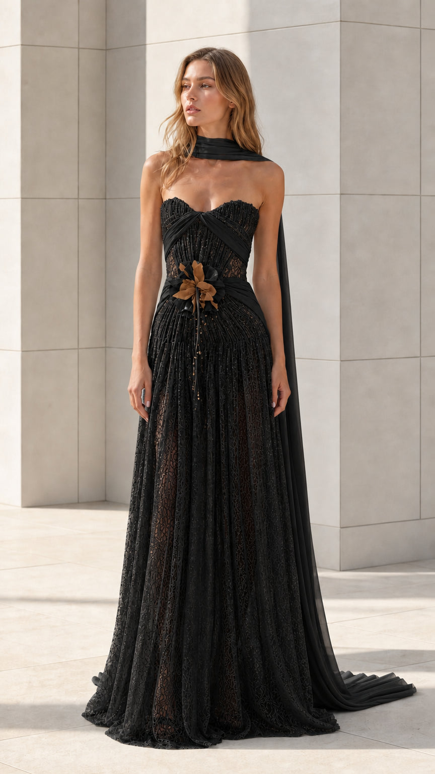 Front view of black strapless lace evening gown with draped scarf