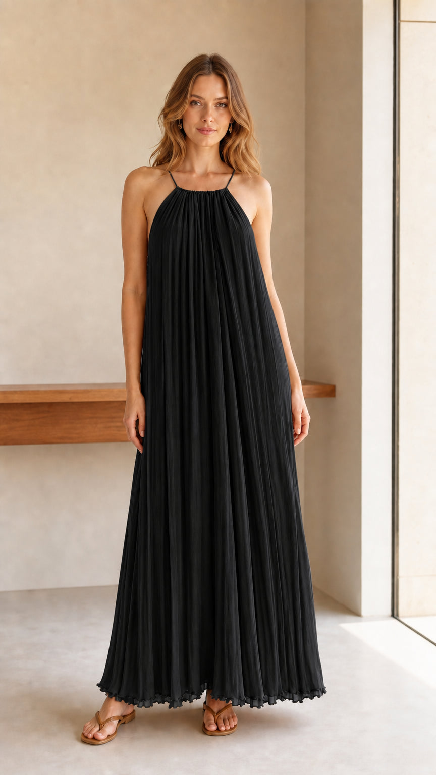 Model wearing black pleated halter maxi dress