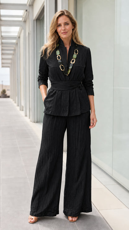 Front view of woman wearing black textured two piece pants set
