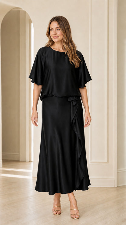 Front view of woman wearing black satin flutter sleeve maxi evening dress
