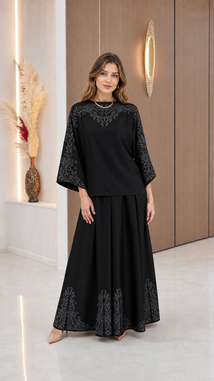Model wearing Black two-piece top and maxi skirt set with tonal border detailing