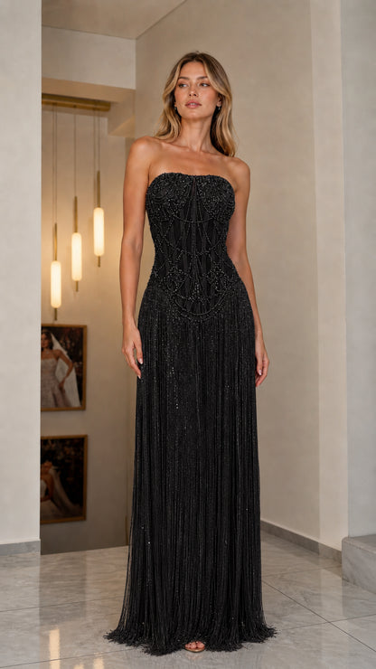 Front view of model in black strapless beaded fringe gown