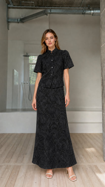 Model wearing black floral embroidered short-sleeve top and maxi skirt matching set