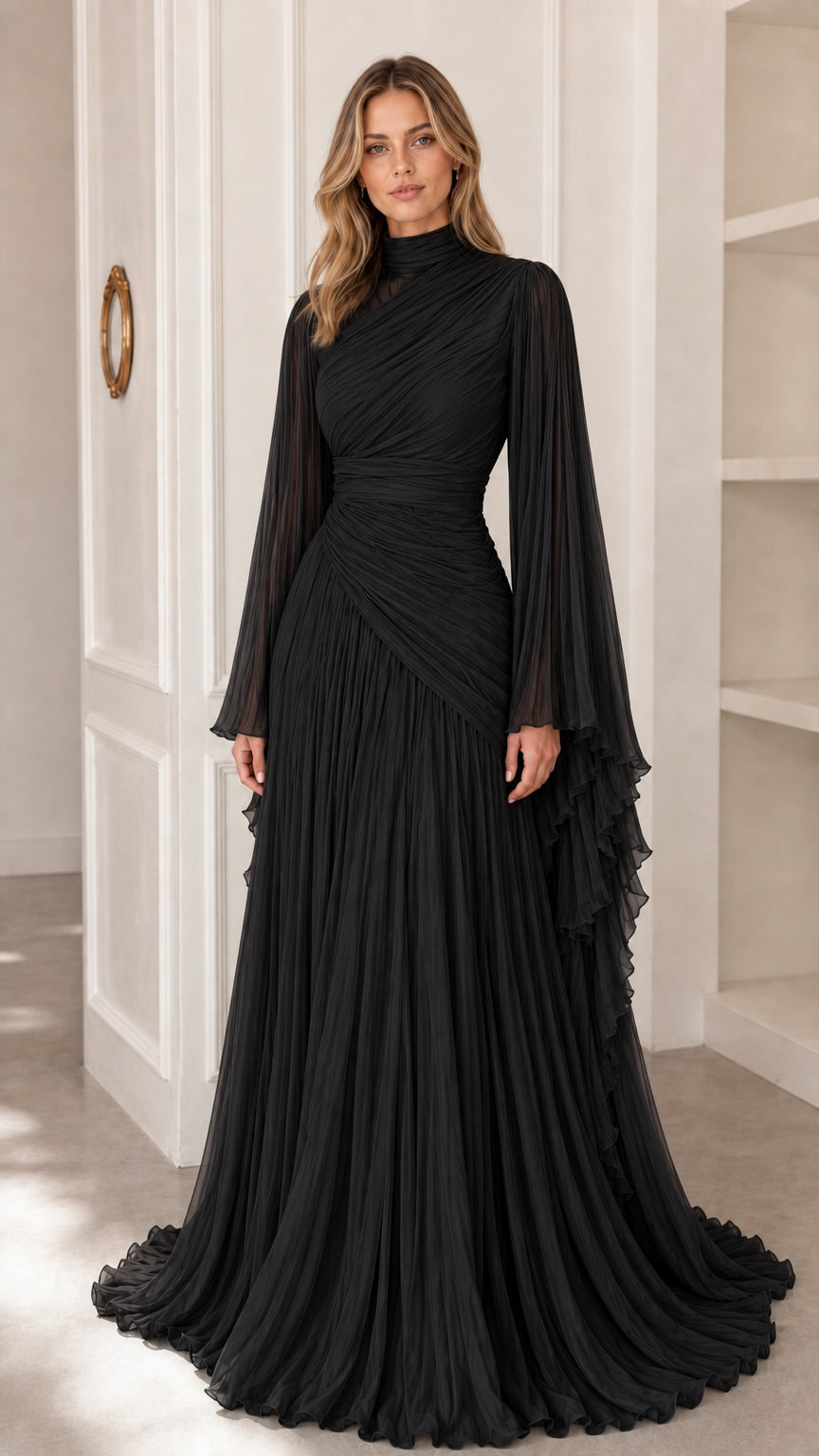 Model wearing classic black pleated high neck evening gown with cape sleeves