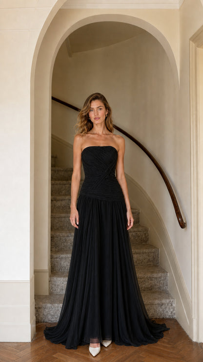 Model wearing black strapless ruched drop-waist maxi evening gown