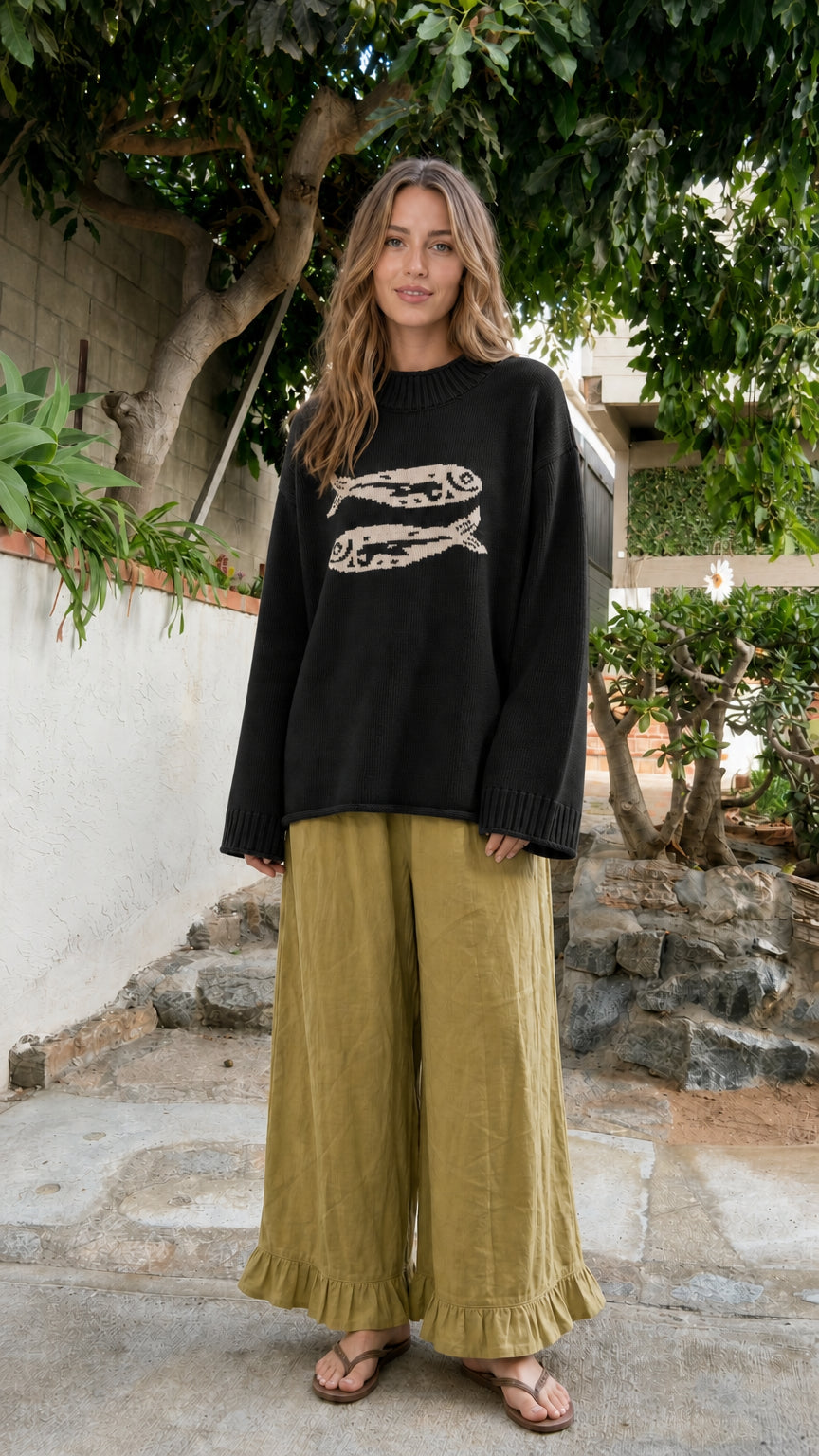 Front view of model wearing Black oversized fish graphic crewneck sweater