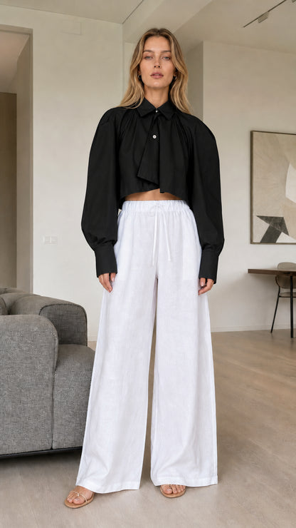 Model wearing black cropped pleated button-down shirt