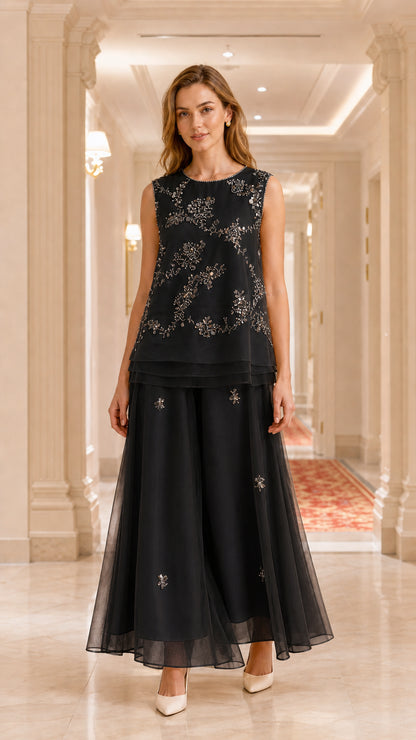 Model wearing black embroidered sleeveless tunic and wide-leg pant set